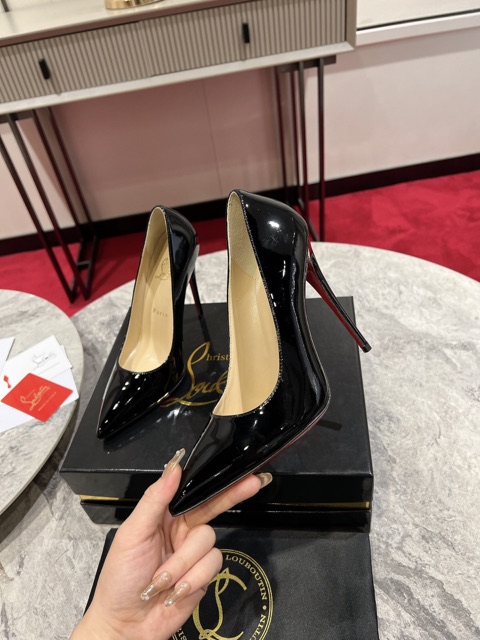 Black patent pump held to show the side profile — supplier photo